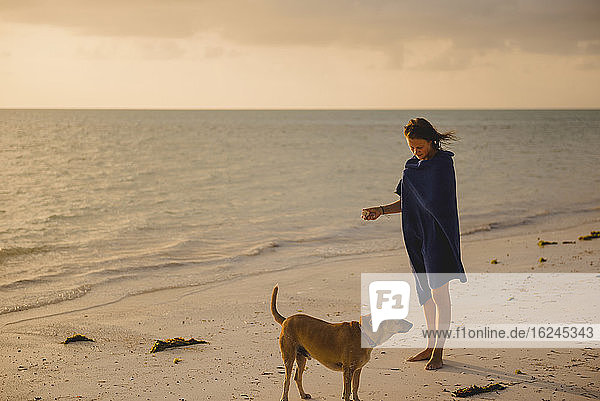 Frau am Strand mit Hund
