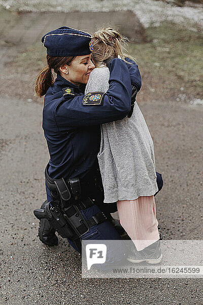 Polizistin  die ihre Tochter umarmt