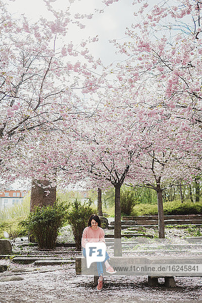 Frau sitzt auf einer Parkbank