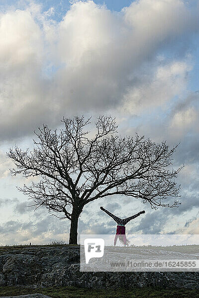Silhouette of woman doing handstand