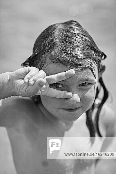 Portrait of girl showing peace sign
