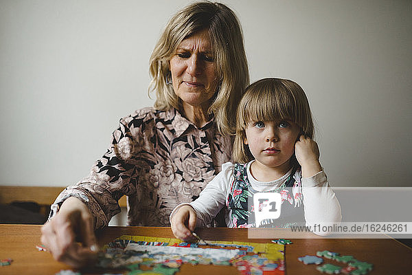 Großmutter und Enkelin beim Puzzeln