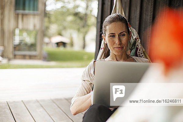 Woman on hammock using laptop