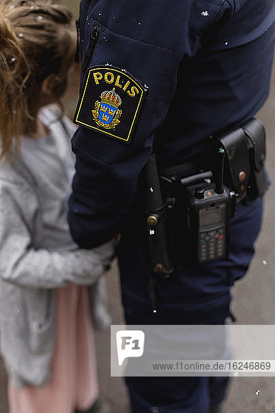Polizistin hält Mädchen an der Hand
