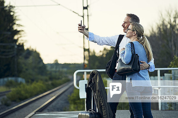 Pärchen macht Selfie auf dem Bahnsteig
