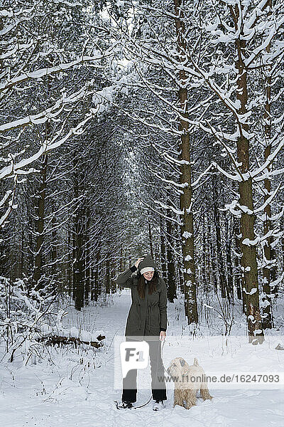 Woman with dog in winter forest