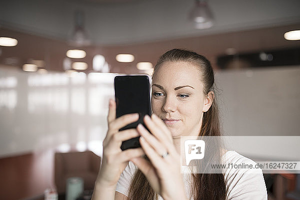Young woman photographing with cell phone