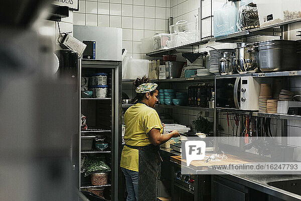 Frau arbeitet in der Küche eines Cafés
