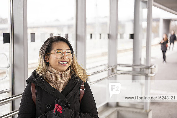 Lächelnde Frau auf dem Bahnhof