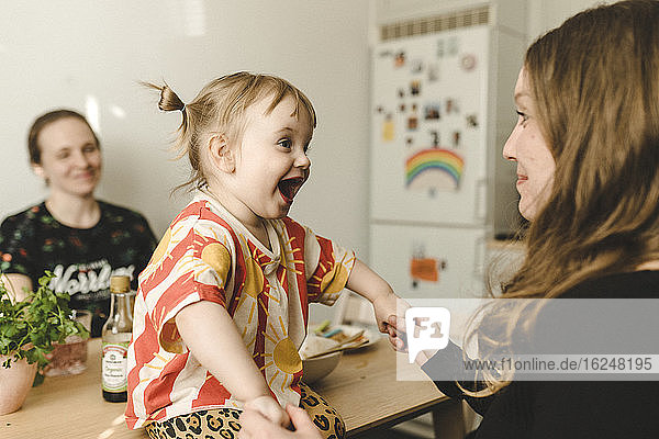 Mutter mit Tochter am Tisch sitzend