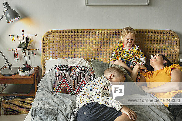 Mother with sons on bed