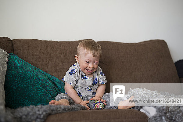 Lachender Junge auf Sofa