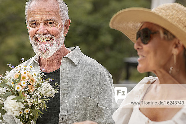 Mature man holding bouquet of flowers