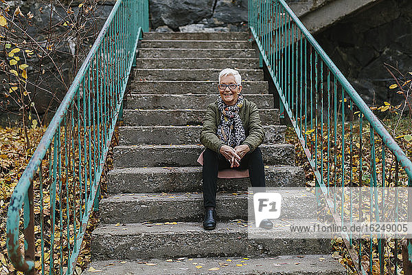 Ältere Frau auf der Treppe sitzend