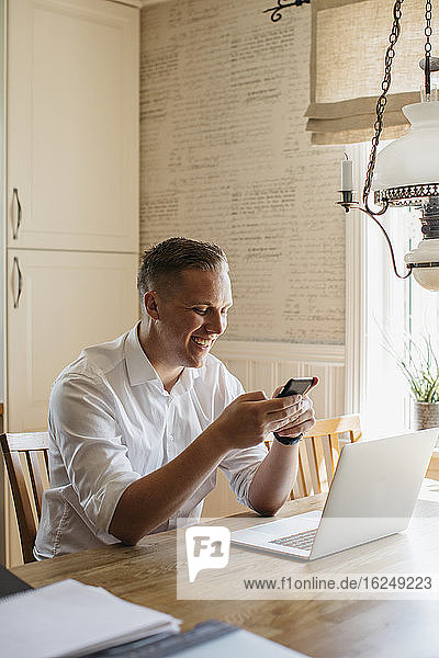 Man sitting at table with cell phone