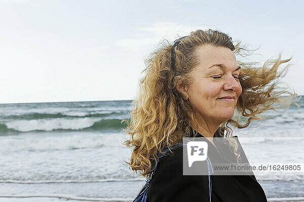 Eine Frau am Meer  deren Haare sich im Wind bewegen