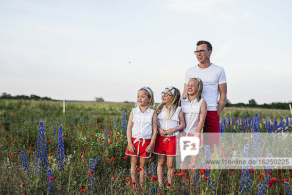 Father and daughters on meadow