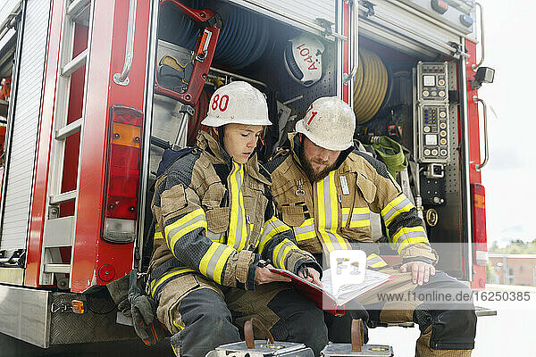 Feuerwehrleute studieren Dokumente