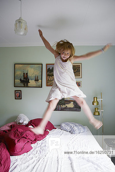 Mädchen springt auf Bett