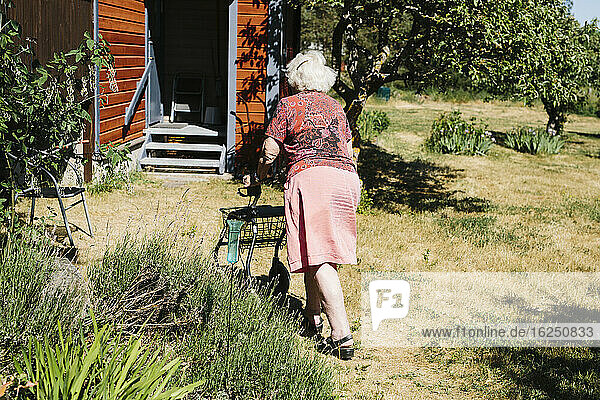 Ältere Frau beim Gehen mit Gehhilfe