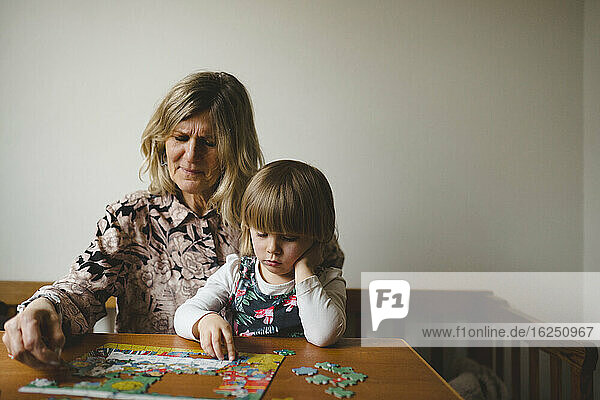 Großmutter und Enkelin beim Puzzeln