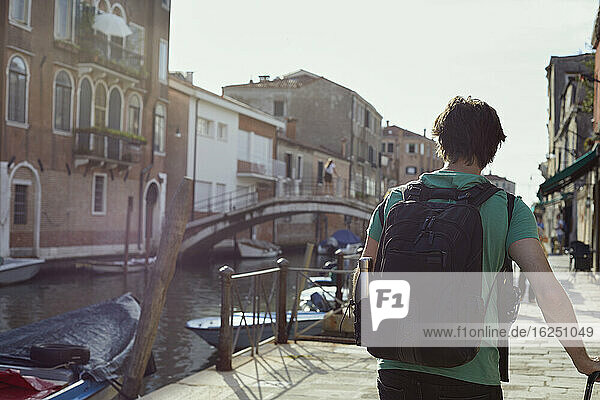 Mann geht entlang eines Kanals  Venedig  Italien