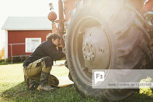 Frau repariert Traktor