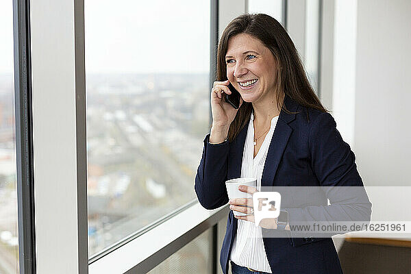 Geschäftsfrau  die über ein Mobiltelefon spricht