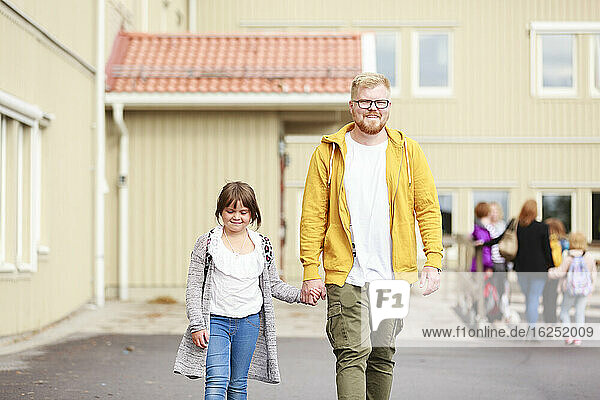 Vater mit Tochter vor dem Schulgebäude