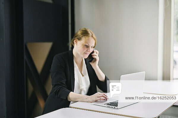 Woman in office talking via cell phone