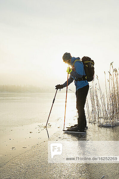 Mann beim Schlittschuhlaufen auf zugefrorenem See