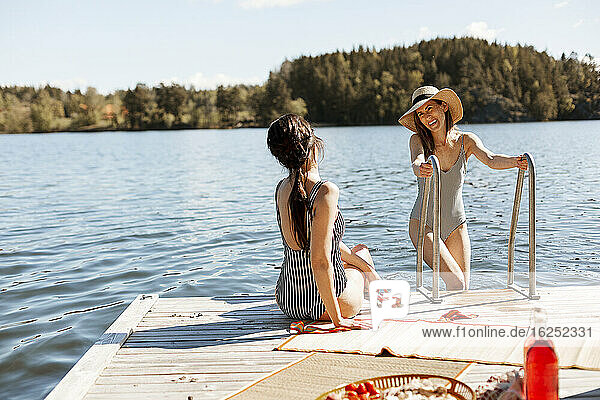 Female friends relaxing on jetty