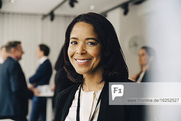 Portrait of smiling businesswoman at office seminar