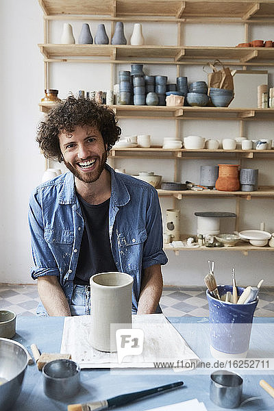 Portrait of smiling man sitting in pottery class