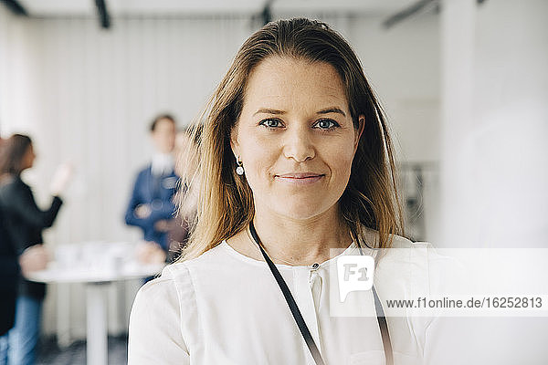 Portrait of smiling businesswoman standing in office