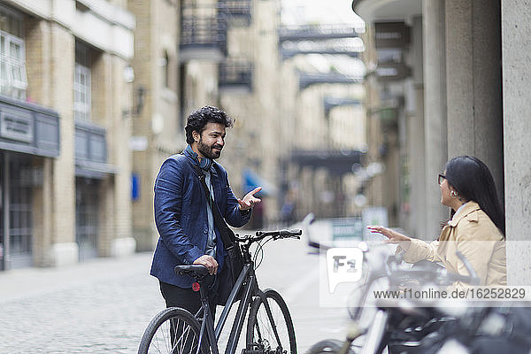 Geschäftsleute mit Fahrrädern im Gespräch auf der Straße