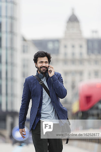 Businessman talking on smart phone in city