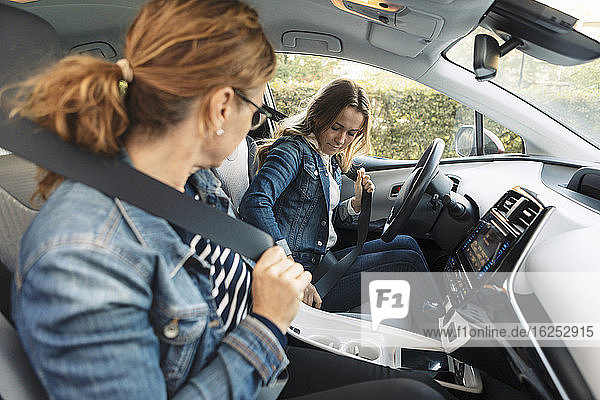 Mutter unterrichtet jugendliches Mädchen am Wochenende im Autofahren