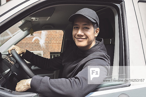 Portrait of smiling delivery person sitting in truck