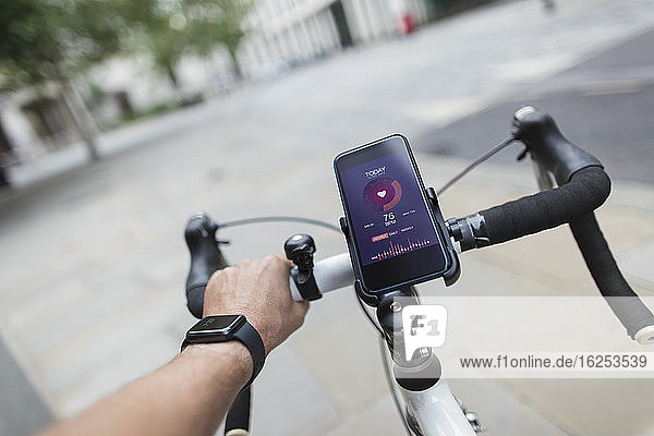 POV Mann auf Fahrrad mit Smartphone-Gesundheitsmonitor