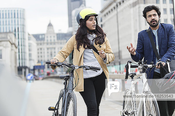 Geschäftsleute mit Fahrrädern auf dem städtischen Bürgersteig