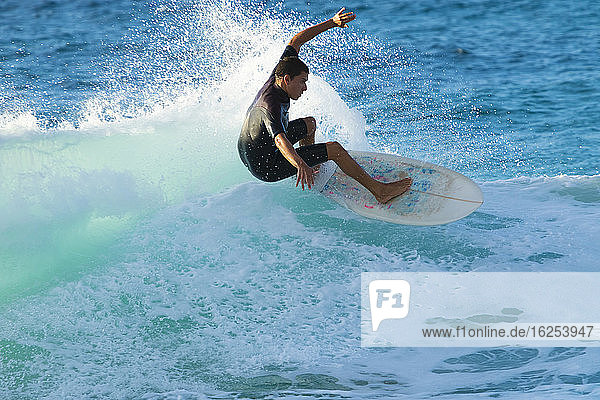 Surfer auf einer türkisfarbenen Welle vor der Nordküste von Oahu; Oahu  Hawaii  Vereinigte Staaten von Amerika