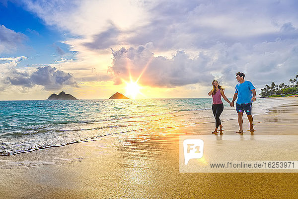 A couple walks on Lanakai beach on the Hawaiian island of Oahu at sunset; Lanakai  Oahu  Hawaii  United States of America