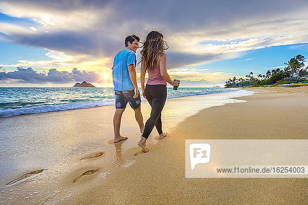A couple walks on Lanakai beach on the Hawaiian island of Oahu at sunset; Lanakai  Oahu  Hawaii  United States of America