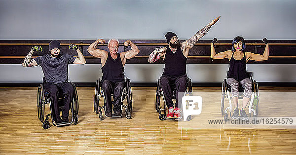 Eine Gruppe querschnittsgelähmter Freunde  die herumalbern und ihre Muskeln nach einem Training in einer Fitnesseinrichtung zeigen: Sherwood Park  Alberta  Kanada