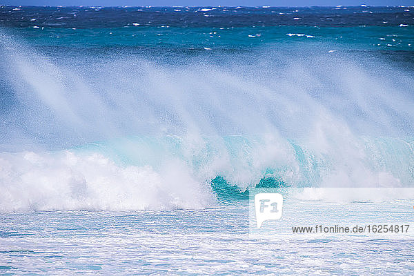 Plätschernde Wellen entlang der Küste mit einem strahlend blauen Himmel am Horizont Banzai-Pipeline; Oahu Hawaii Vereinigte Staaten von Amerika