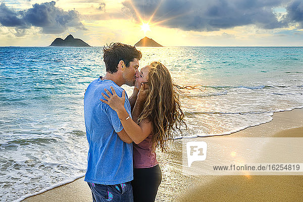 Ein Paar steht bei Sonnenuntergang küssend am Strand von Lanakai auf der hawaiianischen Insel Oahu; Lanakai  Oahu  Hawaii  Vereinigte Staaten von Amerika