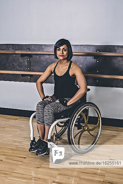 A paraplegic woman taking a break in a gymnasium after working out in a recreational facility: Sherwood Park  Alberta  Canada