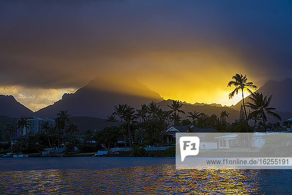 Silhouettierte Palme und Berge bei Sonnenuntergang Ka'elepulu-Kanal; Oahu Hawaii Vereinigte Staaten von Amerika