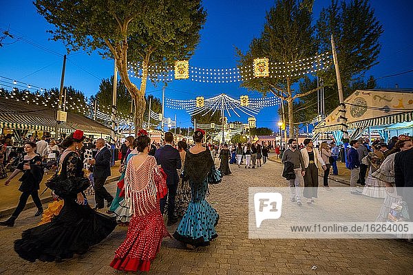 Spanische Frauen mit bunten Flamencokleidern  Abendstimmung  Feria de Abril  Sevilla  Andalusien  Spanien  Europa